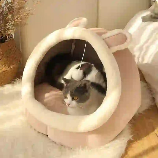 Calming Caveโข Cozy Cat Bed for Deep Sleep featuring a semi-enclosed pink design with plush lining and playful ear accents, ideal for indoor cats.